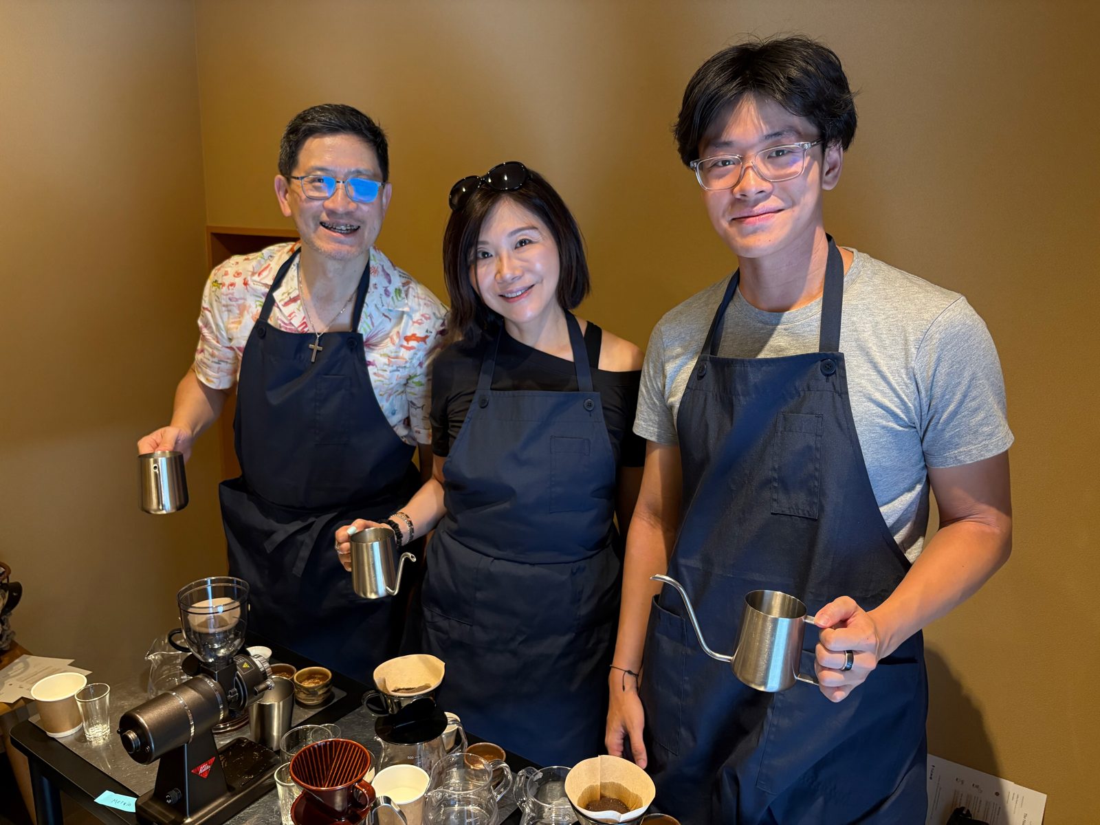 Smiling guests holding gooseneck kettles, ready to brew
