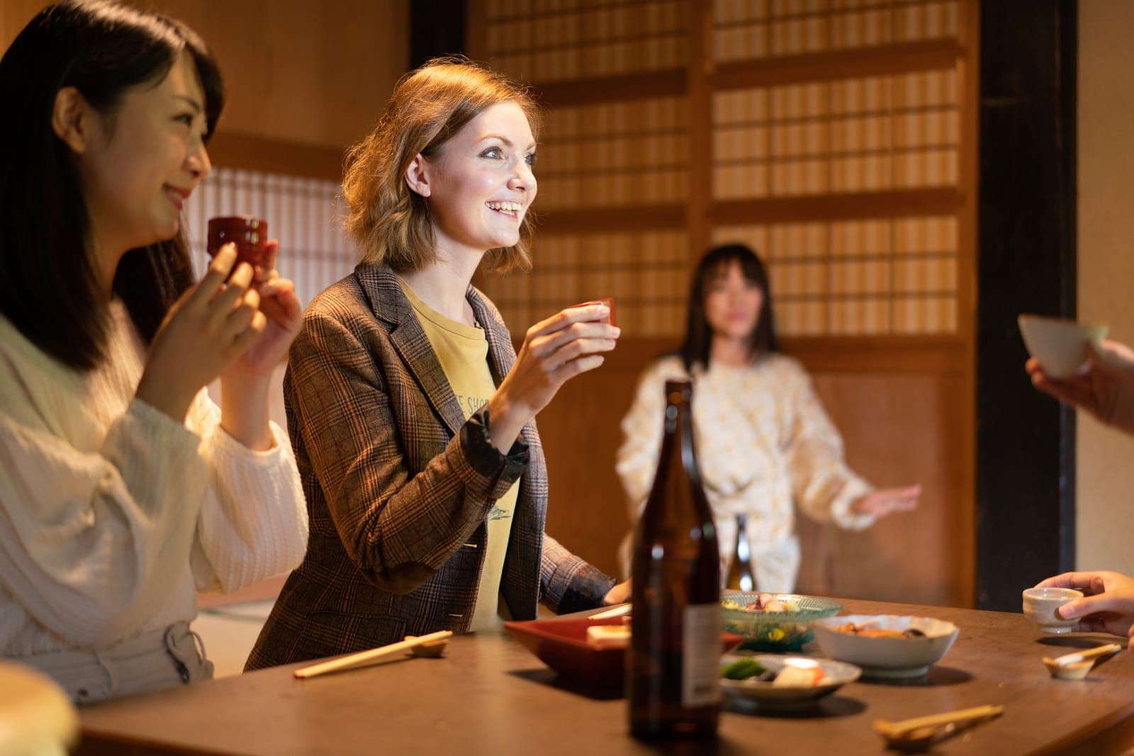 Guests enjoying food and drinks inside a Kyoto izakaya