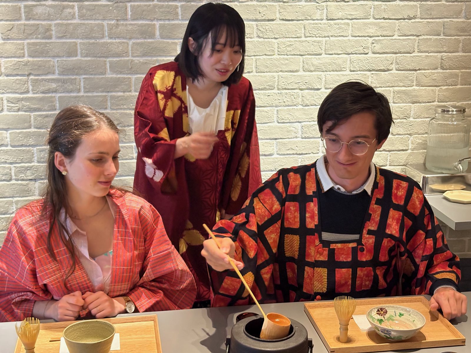 The sensei explaining the bamboo ladle and iron kettle to guests